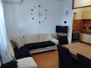 a living room with a couch and a clock on the wall at House B - with spacious terrace and beautiful view in Omiš