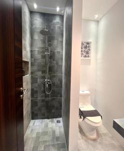 a bathroom with a shower with a toilet at oxy suites 1-01 at Shop House Meisterstadt Pollux Habibie in Batam Center