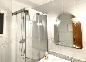 a bathroom with a shower and a sink with a mirror at Apartamentos Ulia in Benidorm