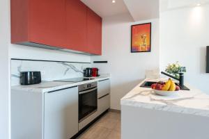 eine Küche mit roten Schränken und einer Obstschale auf der Theke in der Unterkunft CROISETTE BEACH - Modern 2 Bdrs Best Location! in Cannes