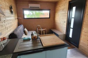 - une cuisine dans une petite maison avec une planche de coupe sur un comptoir dans l'établissement Tiny House sud du Lot, à Le Montat