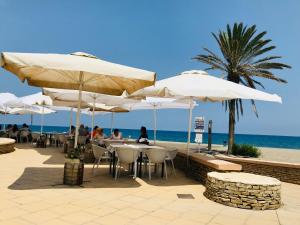 people sitting at tables under umbrellas near the beach at Lancón Boutique Carboneras in Carboneras