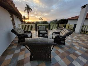 a patio with chairs and a couch on a tile floor at Pousada Luar do Rosário in Milho Verde