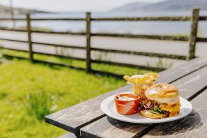 une assiette de nourriture avec un sandwich et des chips sur une table dans l'établissement Inn at Port nan Gael, à Pennyghael