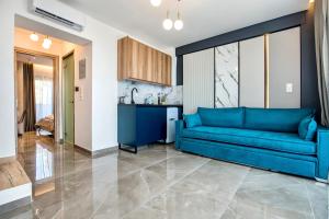 uma sala de estar com um sofá azul e uma cozinha em Aigli Skala Maries Deluxe em Skala Marion