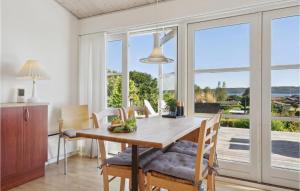 uma sala de jantar com mesa e cadeiras e uma grande janela em Lovely Home In Brkop With Kitchen em Børkop