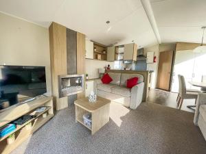 un piccolo soggiorno con divano e TV di Caravan With Decking And Free Wifi At Seawick Holiday Park Ref 27214sw a Clacton-on-Sea