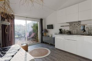 cocina con armarios blancos y ventana grande en Studio indépendant proche Aix-en-Provence, en Châteauneuf-le-Rouge