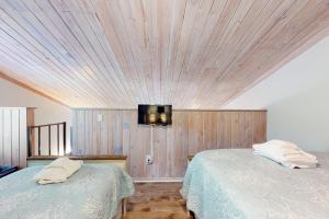 una camera da letto con due letti e una TV a parete di Driftwood Villa - 261 Palmetto Perch a Edisto Island