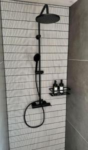 eine Dusche mit drei Regalen an der Wand eines Badezimmers in der Unterkunft BEACHHOUSE #1 - Buqez Resort in Drage