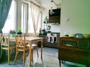 uma cozinha com uma mesa e cadeiras de madeira e uma cozinha com um fogão em Comfy boho-studio in Kallio. em Helsínquia