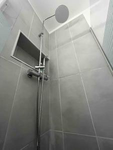 a shower with a shower head in a bathroom at K3- Maison 2min RER 15min PARIS-EXPO 4 chambres/10 lits in Bagneux