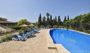 una piscina con sillas y sombrillas azules en Na Pont, en Campos