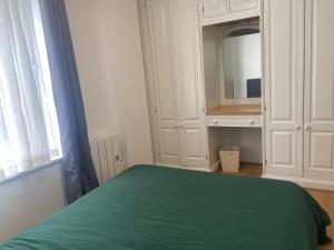 a bedroom with a green bed and a mirror at Prime Location Apartment - Heart of London in London