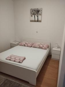 - un lit blanc avec 2 oreillers dans la chambre dans l'établissement House B - with spacious terrace and beautiful view, à Omiš