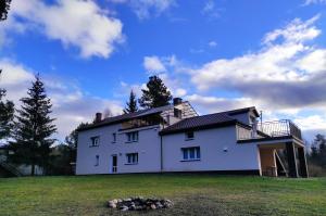 a large white house on top of a field at Agroturystyka Huta in Krzywe