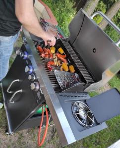 a man is cooking food on a grill at Agroturystyka Huta in Krzywe