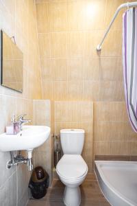 een badkamer met een toilet, een wastafel en een bad bij Pokoje u Kasi in Mielno