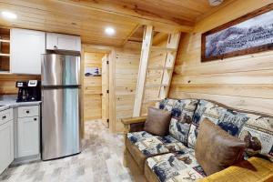 a living room with a couch and a refrigerator at Down the Creek in Gatlinburg