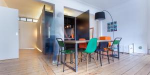 uma sala de jantar com uma mesa e cadeiras verdes em B&B - Apartment - Peace in the City em Antuérpia