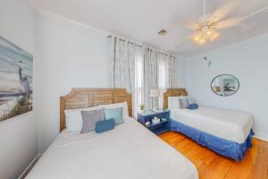 - une chambre avec 2 lits et une fenêtre dans l'établissement Coastal Breeze, à Galveston