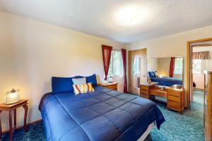 Schlafzimmer mit einem blauen Bett und einem Schreibtisch in der Unterkunft Twin Lakes Gem in Rathdrum
