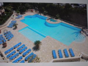 an overhead view of a large swimming pool with blue chairs at VILLA MAUPASSANT BORD DE MER in Cannes