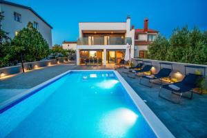 uma piscina com cadeiras e uma casa em Villa La Perla Pula,Kroatien em Pula