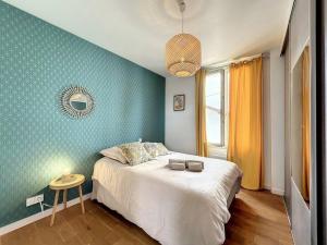 - une chambre dotée d'un lit avec un mur bleu dans l'établissement Appartement de charme Erdizka, à Bayonne