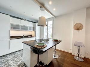 a kitchen with a island in the middle of a room at Appartement de charme Erdizka in Bayonne