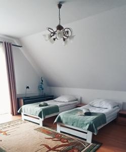 にあるRychtyńska Ciszaのベッドルーム1室(ベッド2台、シーリングファン付)