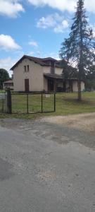 uma grande casa branca com uma árvore em frente em Corneguerre Grand Brassac em La Peyzie