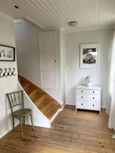 um quarto com uma escada, uma cadeira e uma cómoda em Charmig villa norr om Stockholm em Vallentuna