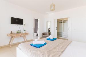 1 dormitorio con 1 cama con 2 toallas en Sunset White Villa - Ocean view, sunset,pool,grill, en Playa de las Américas