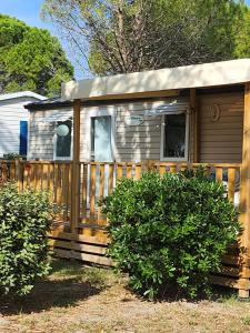 ein winziges Haus mit einem Holzzaun in der Unterkunft Mobil-home tout confort in Sigean