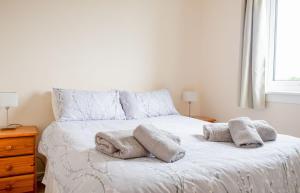 a bedroom with a bed with towels on it at Sorley's House in Stenscholl