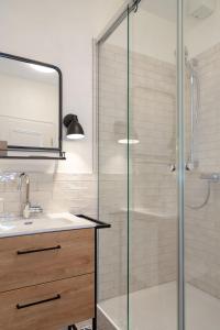a bathroom with a glass shower and a sink at Backbord in Westerland (Sylt)