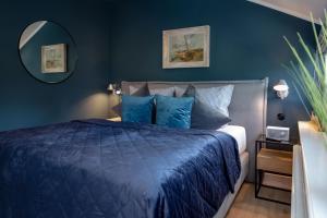 Dormitorio azul con cama y espejo en Backbord, en Westerland