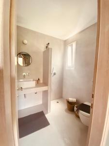 貝尼蔡斯的住宿－Lord Ape Suites Club，白色的浴室设有水槽和卫生间。