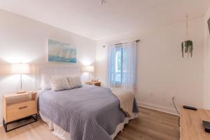 um quarto branco com uma cama e uma janela em Coastal Luxe Villa by the Beach em Hilton Head Island