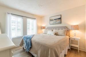 um quarto com uma cama e duas janelas em Coastal Luxe Villa by the Beach em Hilton Head Island