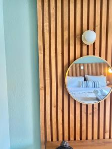 a bedroom with a mirror on a wooden wall at Lord Ape Suites Club in Benitses