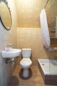 a bathroom with a toilet and a sink and a mirror at Pokoje u Kasi in Mielno