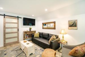 a living room with a couch and a tv at Kitty Hawk Vacation Rental with Pool and Hot Tub in Kitty Hawk