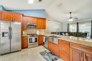 a kitchen with wooden cabinets and stainless steel appliances at Minneola Home with Screened Porch, 25 Mi to Disney! in Minneola
