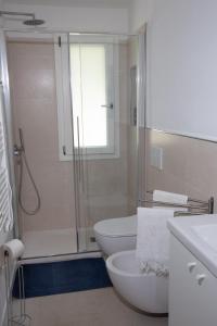 een witte badkamer met een douche en een toilet bij Villino Marigia in Geremèas