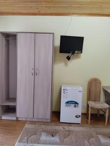 a white cabinet and a television in a room at В Гостях на Иссык-Куле in Cholpon-Ata