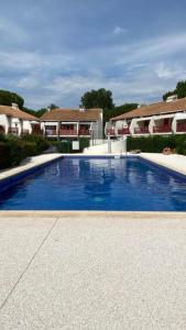 uma grande piscina azul em frente a algumas casas em Charmant T2 avec grande terrasse et confort 3 étoiles em La Grande-Motte