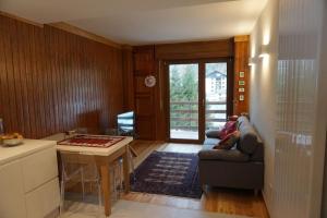 a kitchen and living room with a couch and a table at Miri Apartment in Alagna Valsesia