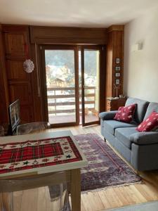 a living room with a couch and a table at Miri Apartment in Alagna Valsesia